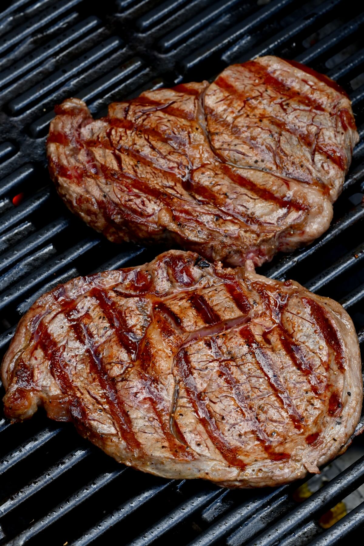 two grilled steaks on grill with grill marks
