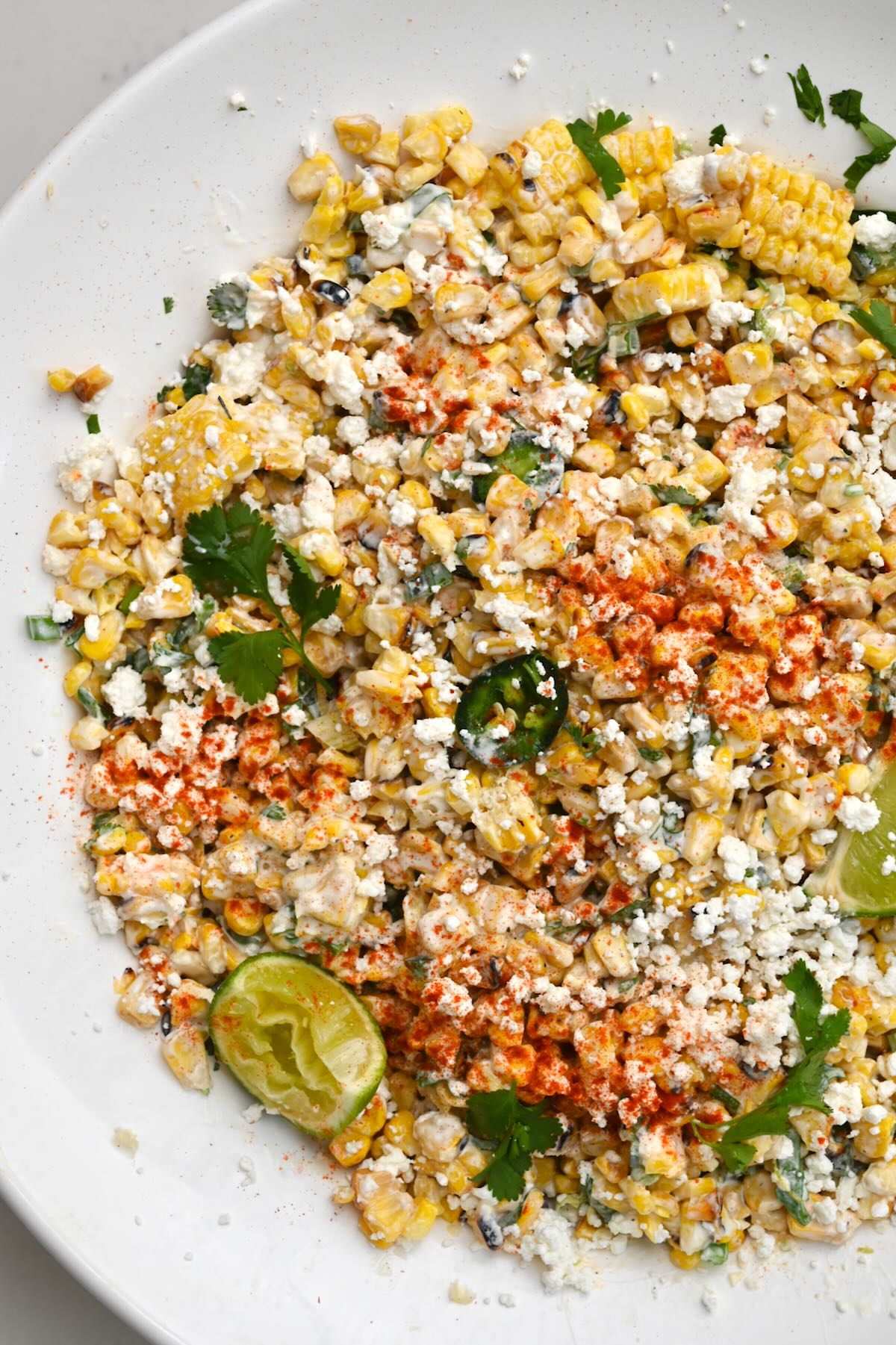 top view close up of mexican street corn salad in a white large plate.