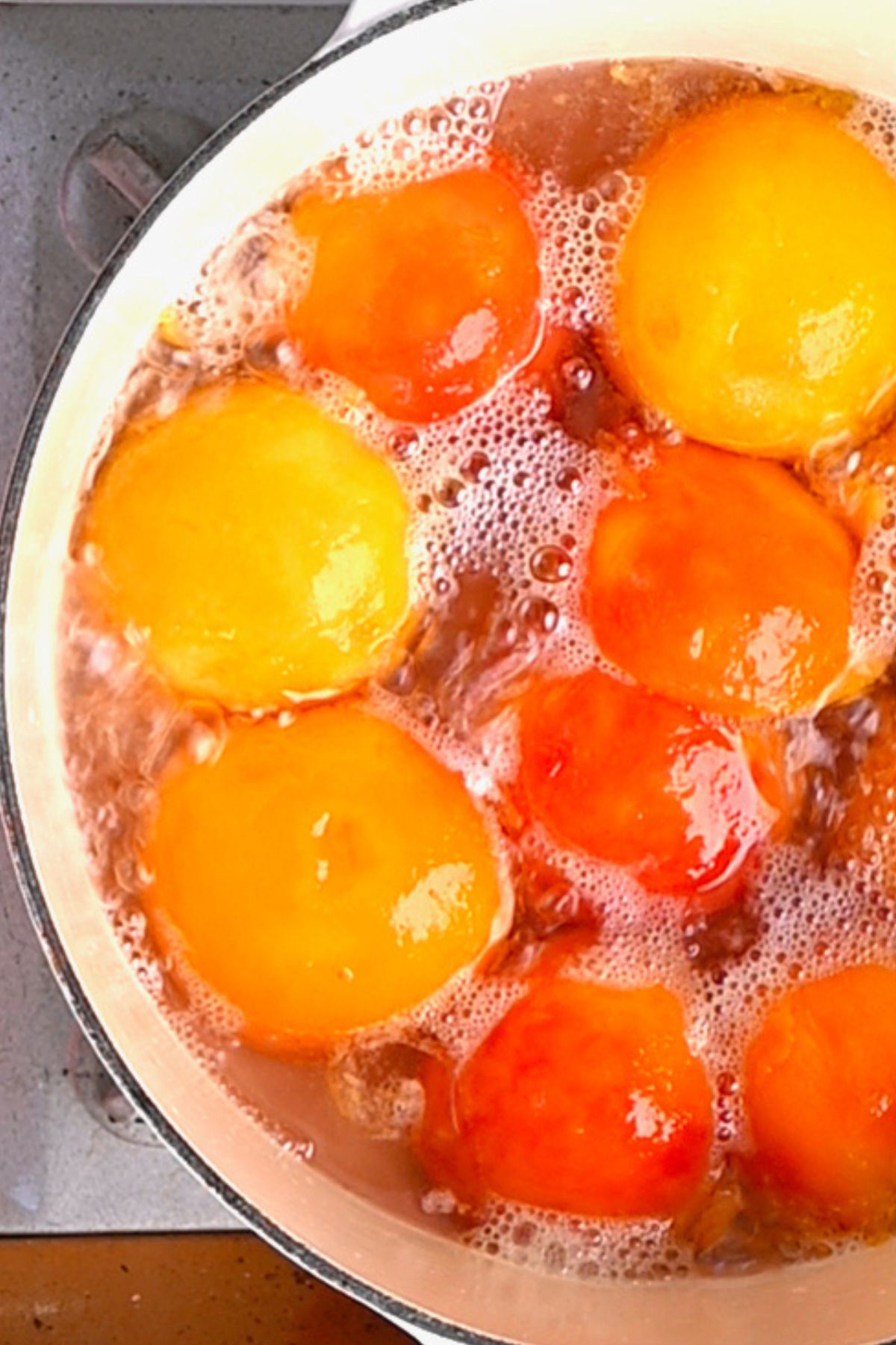 Halved peaches cooking in a pot in preparation for canning. - 6