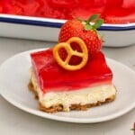 Slice of Strawberry Pretzel Salad with all three layers, topped with a small pretzel and a fresh strawberry. - 14