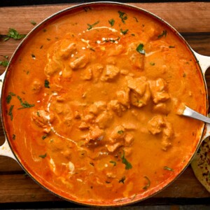 top view of butter chicken recipe in a large white skillet - 12