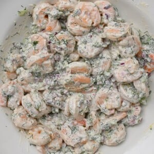 square photo of shrimp salad on a white plate showing the texture and the creamy dressing