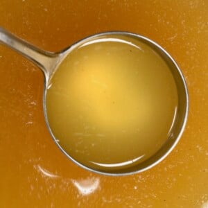 Top view of a ladle filled with turkey stock