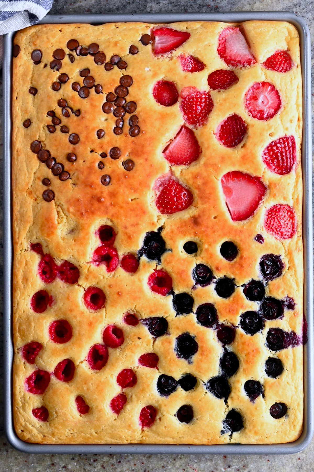 Sheet pan pancakes topped with raspberries, blueberries, strawberries, and chocolate chips. - 1