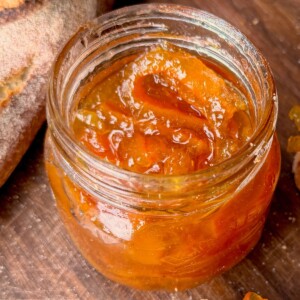 Close-up of glossy orange marmalade in a jar.