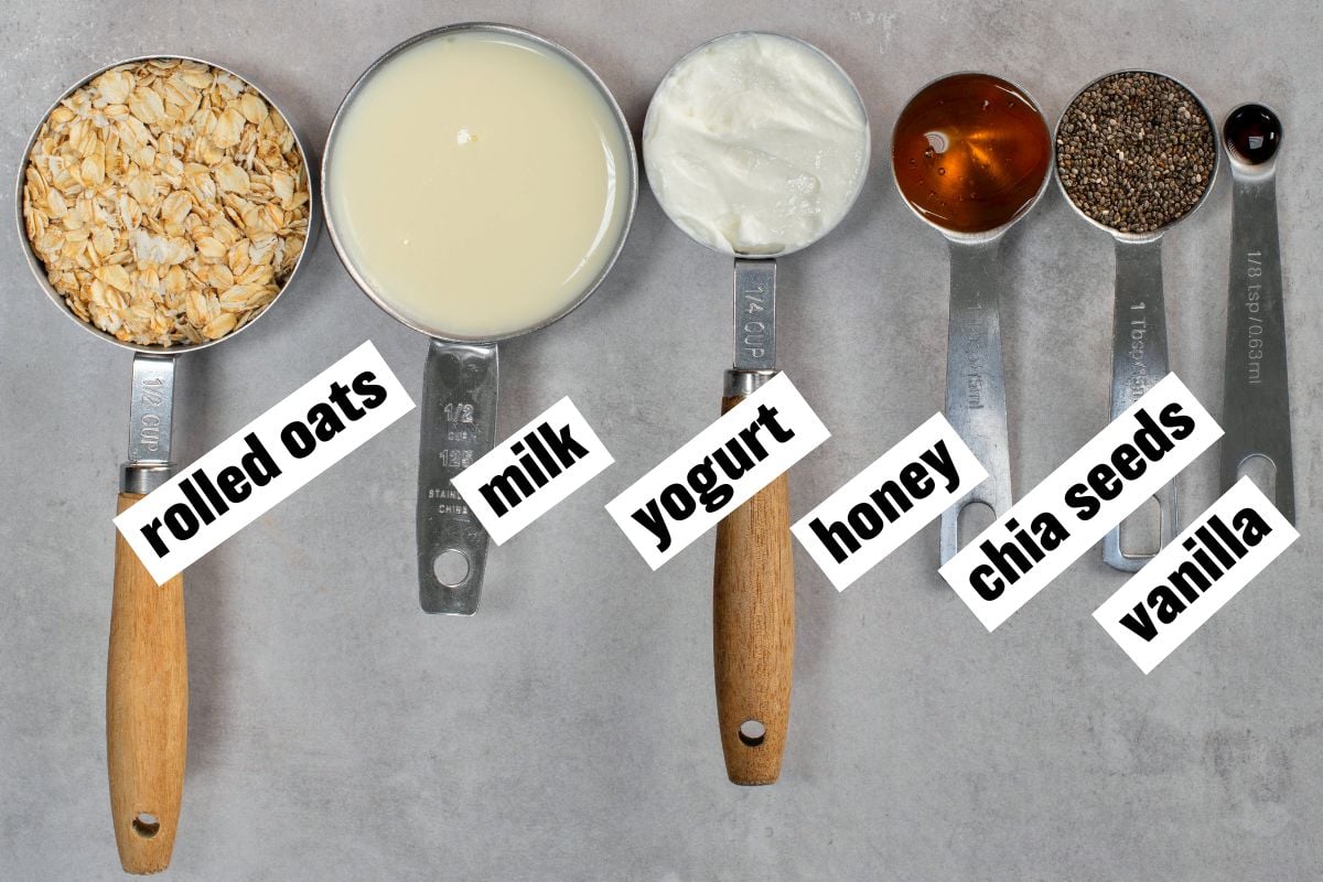 Flatlay of ingredients for overnight oats arranged on a concrete surface.