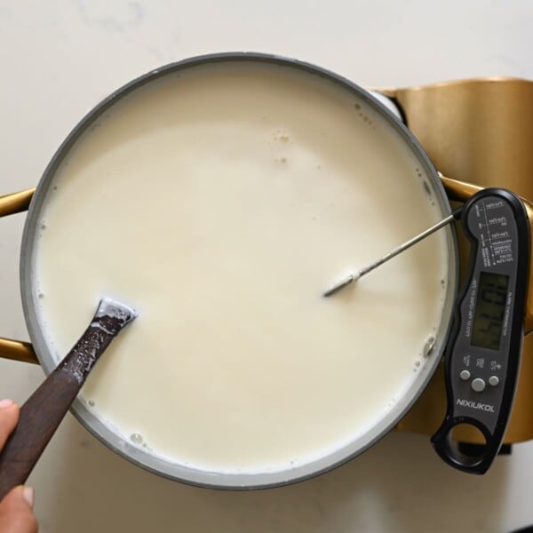 Heating and stirring milk in a large pan.