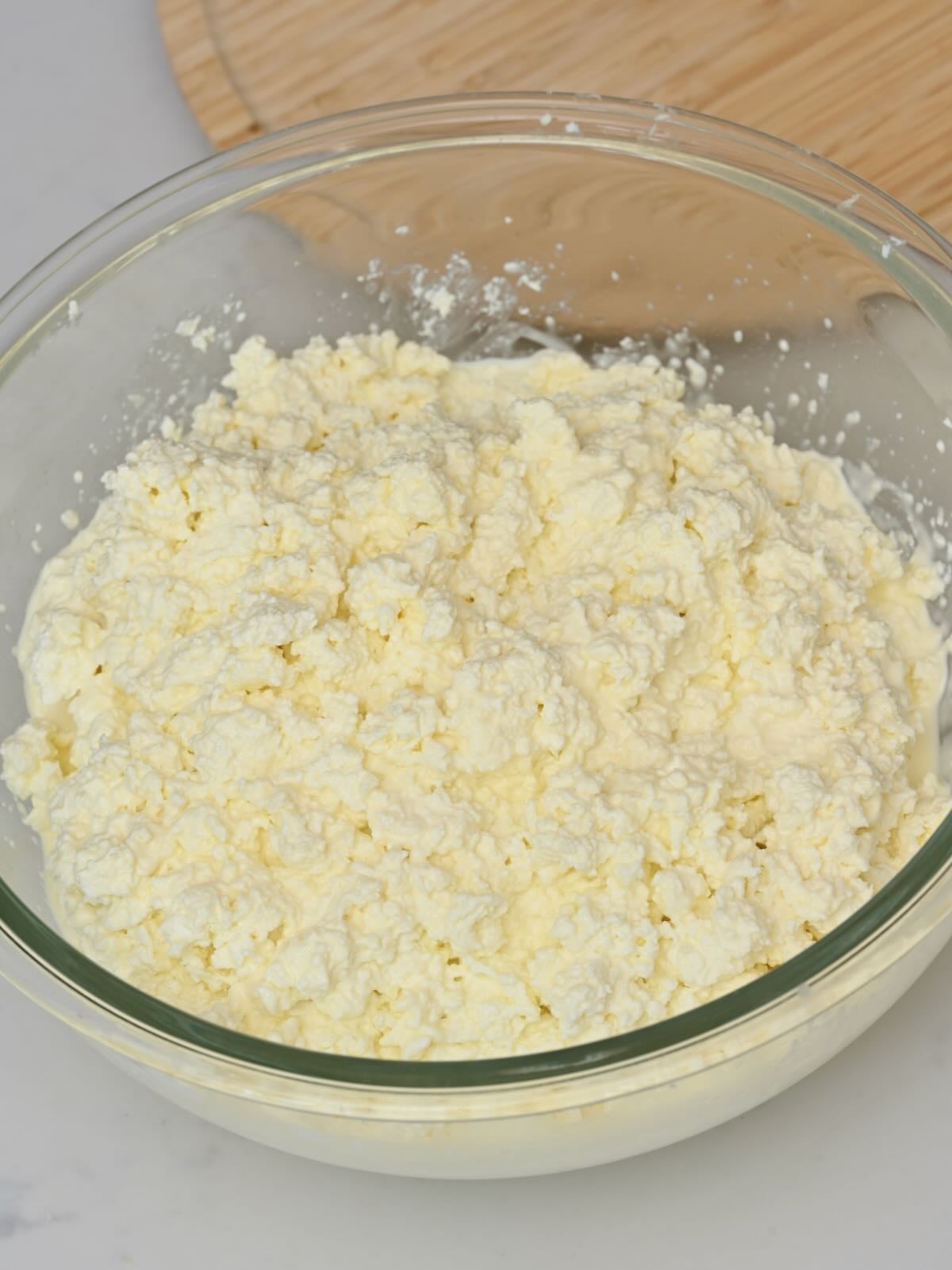 A bowl of creamy and fluffy homemade cottage cheese.