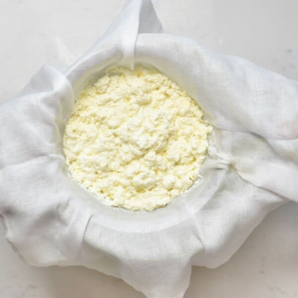 Draining milk curds over a muslin cloth.