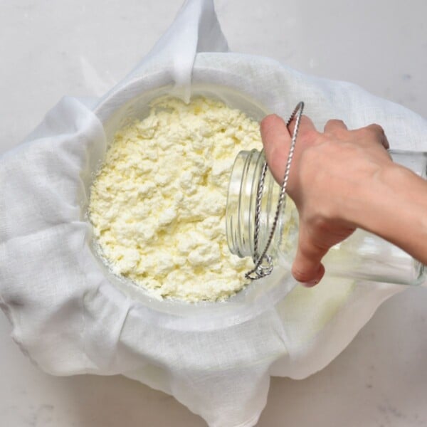 Rinsing milk curds with a bit of cold water.