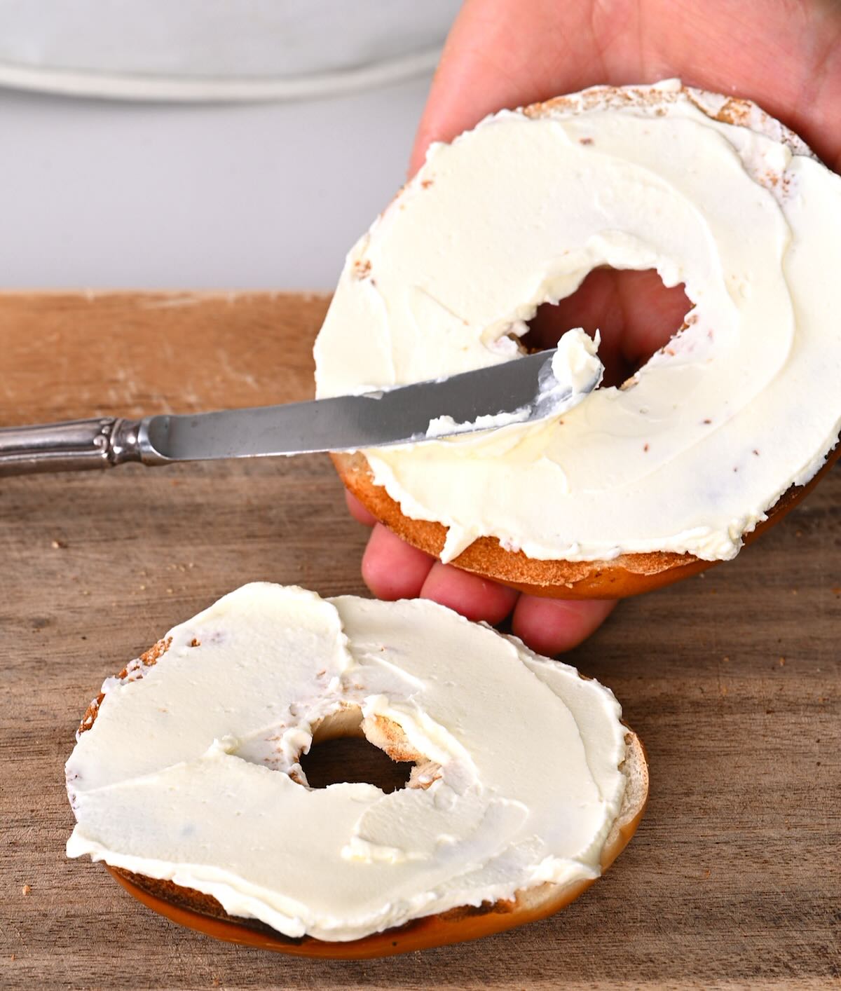 Spreading homemade cream cheese on a bagel.
