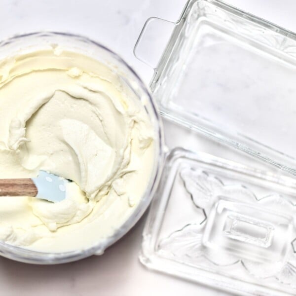 Storing homemade cream cheese in a glass container.