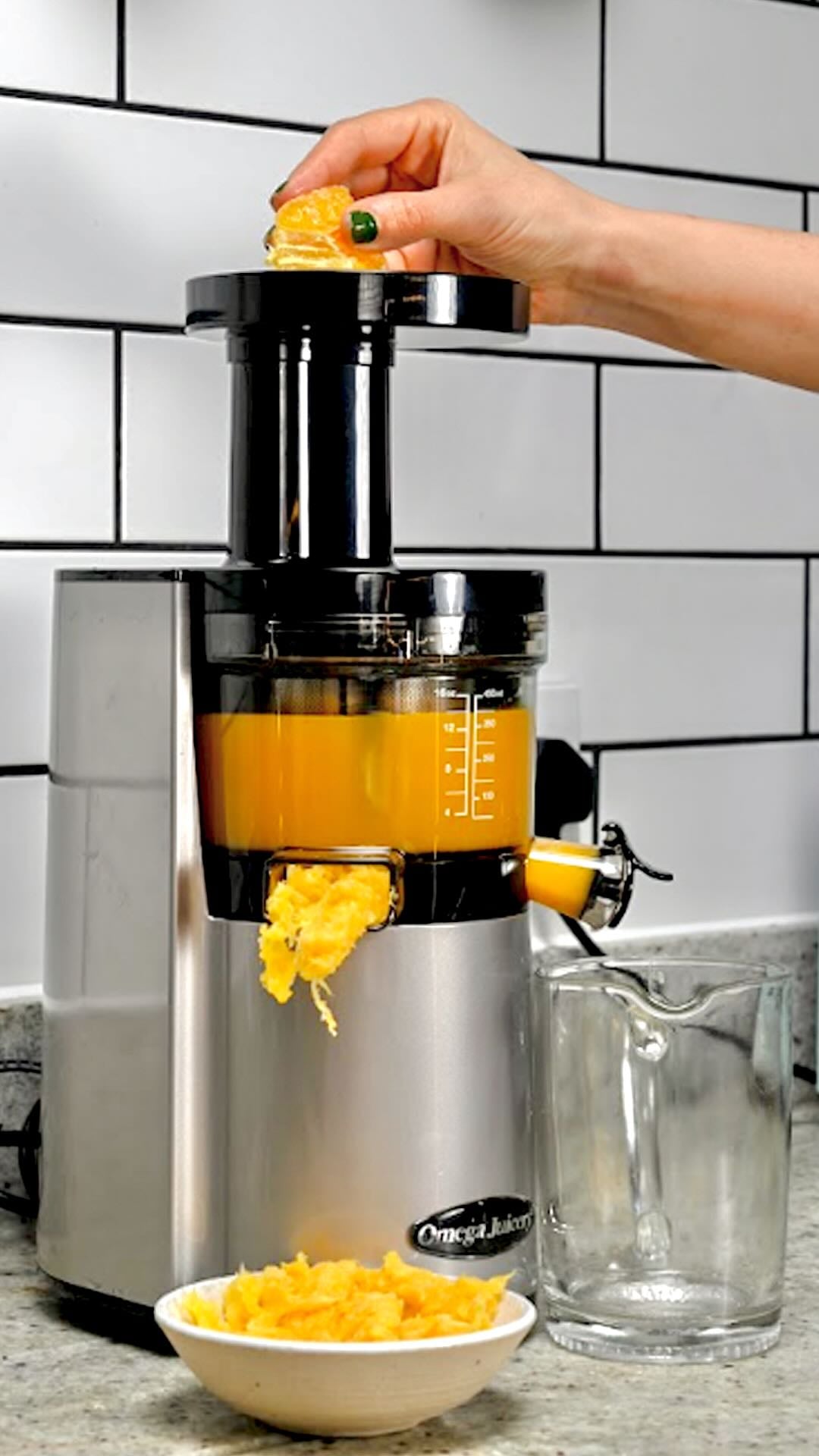 Feeding orange segments into a juicer.