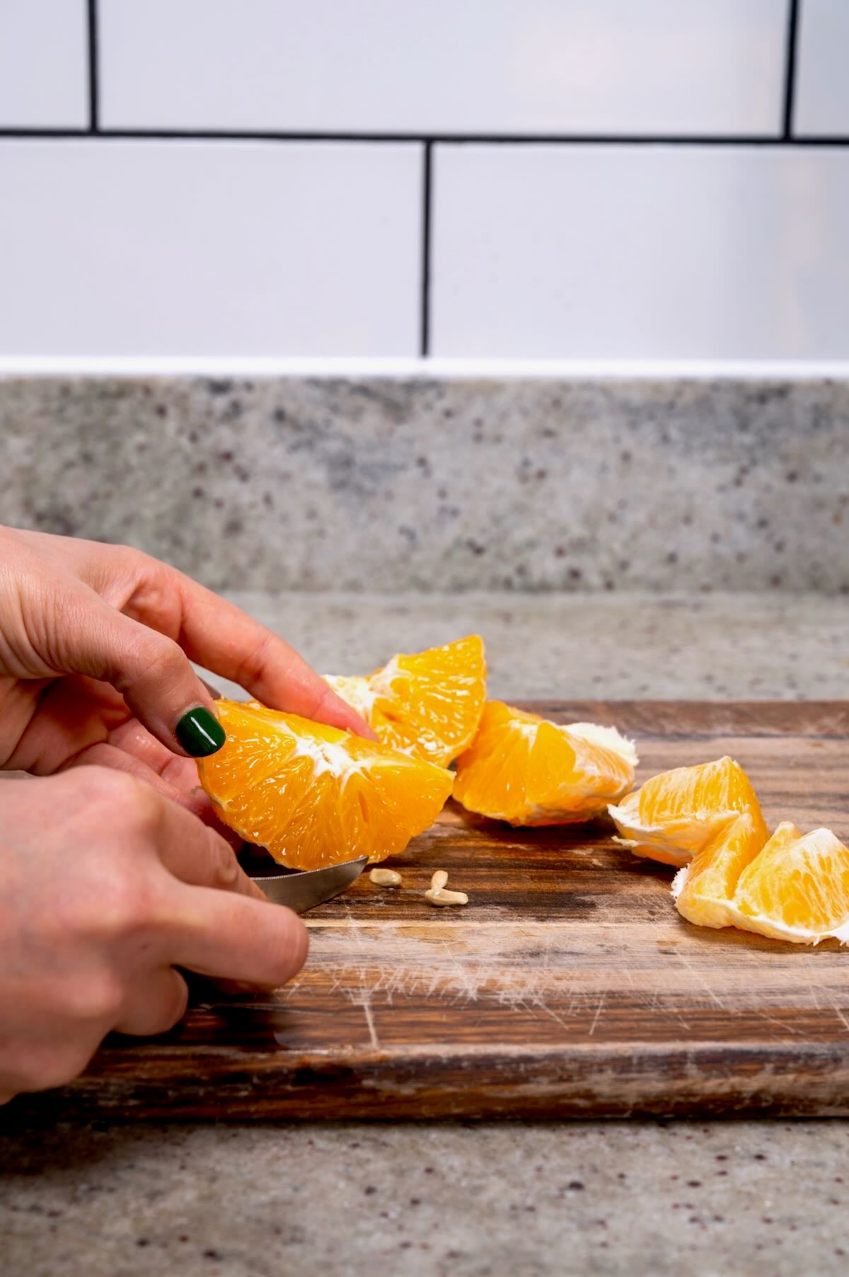 Removing the seeds from orange segments.