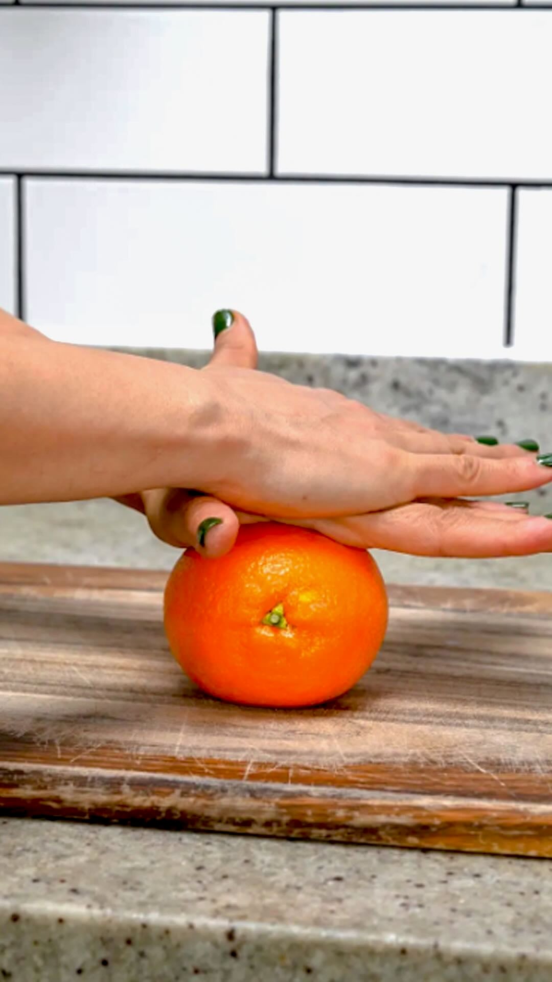 Rolling an orange on a wooden board.