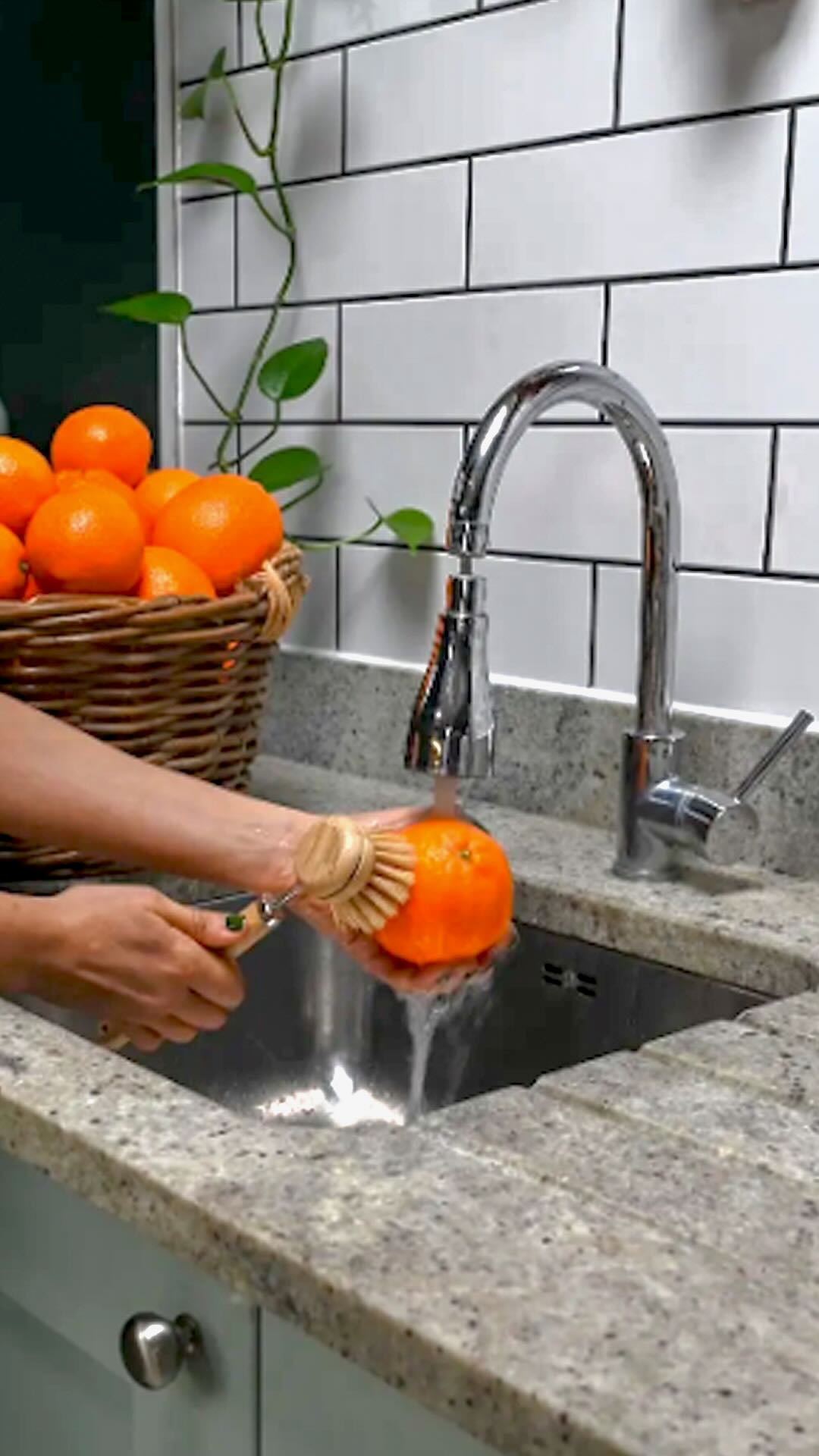 Scrubbing an orange with a brush.