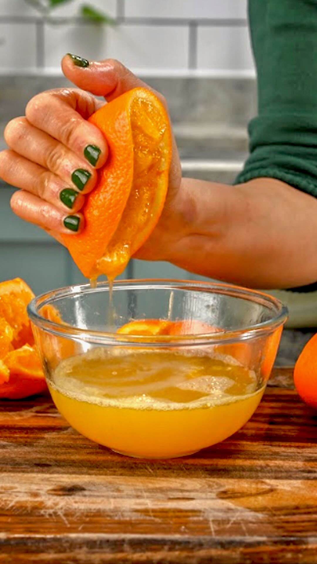 Squeezing out orange juice by hand over a bowl.