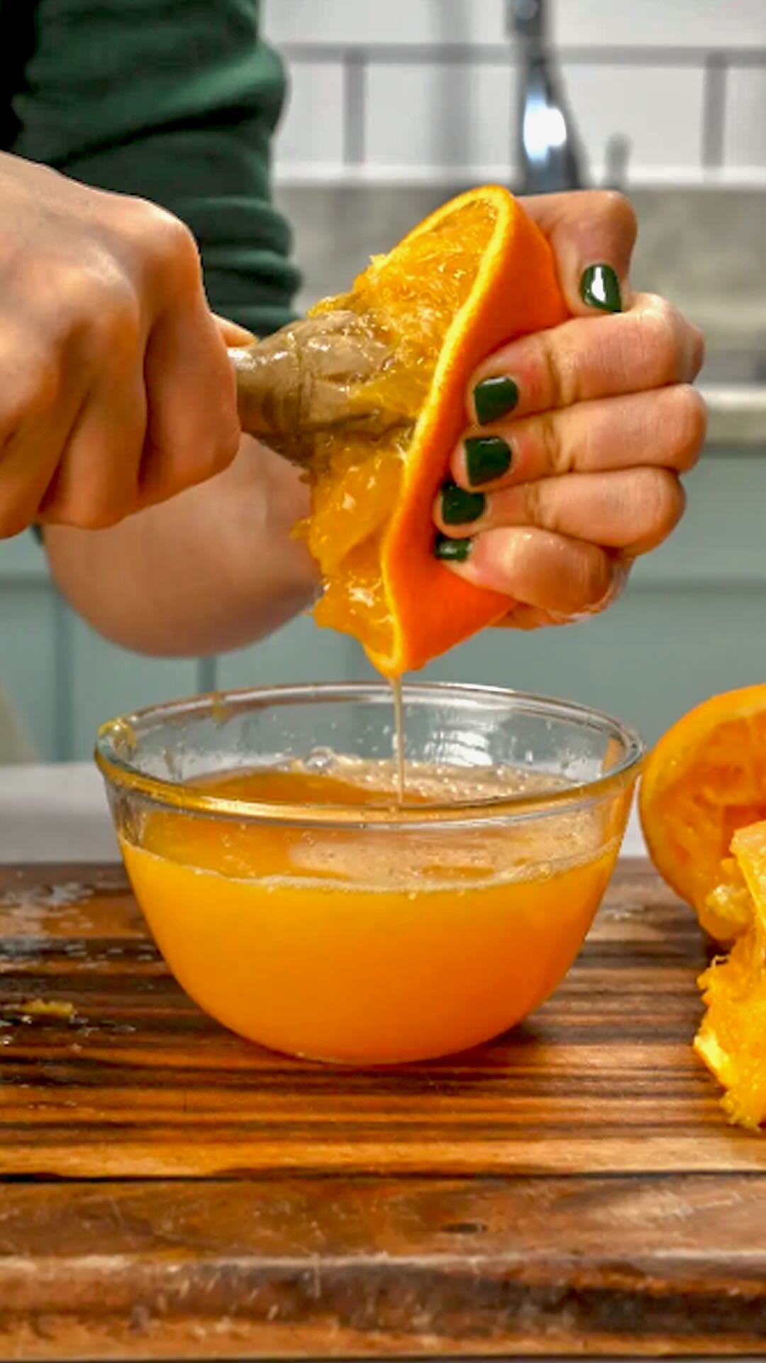 How to Make Orange Juice - Using a wooden reamer to make orange juice over a bowl. Using a wooden reamer to make orange juice over a bowl.