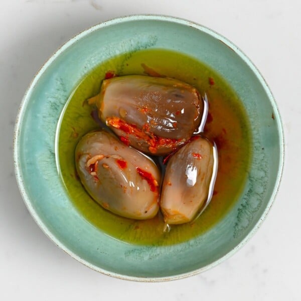 Makdous served on a green plate with olive oil.