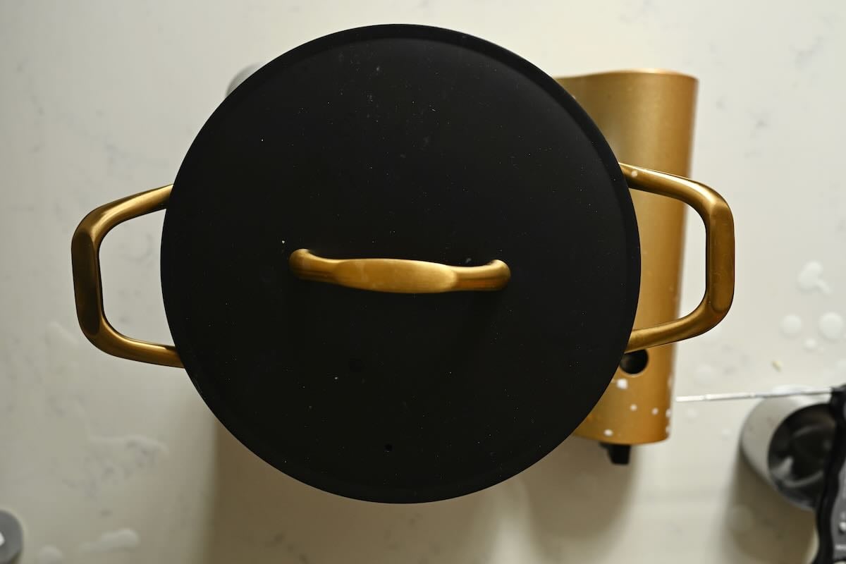 Letting the heated milk rest in the pot.