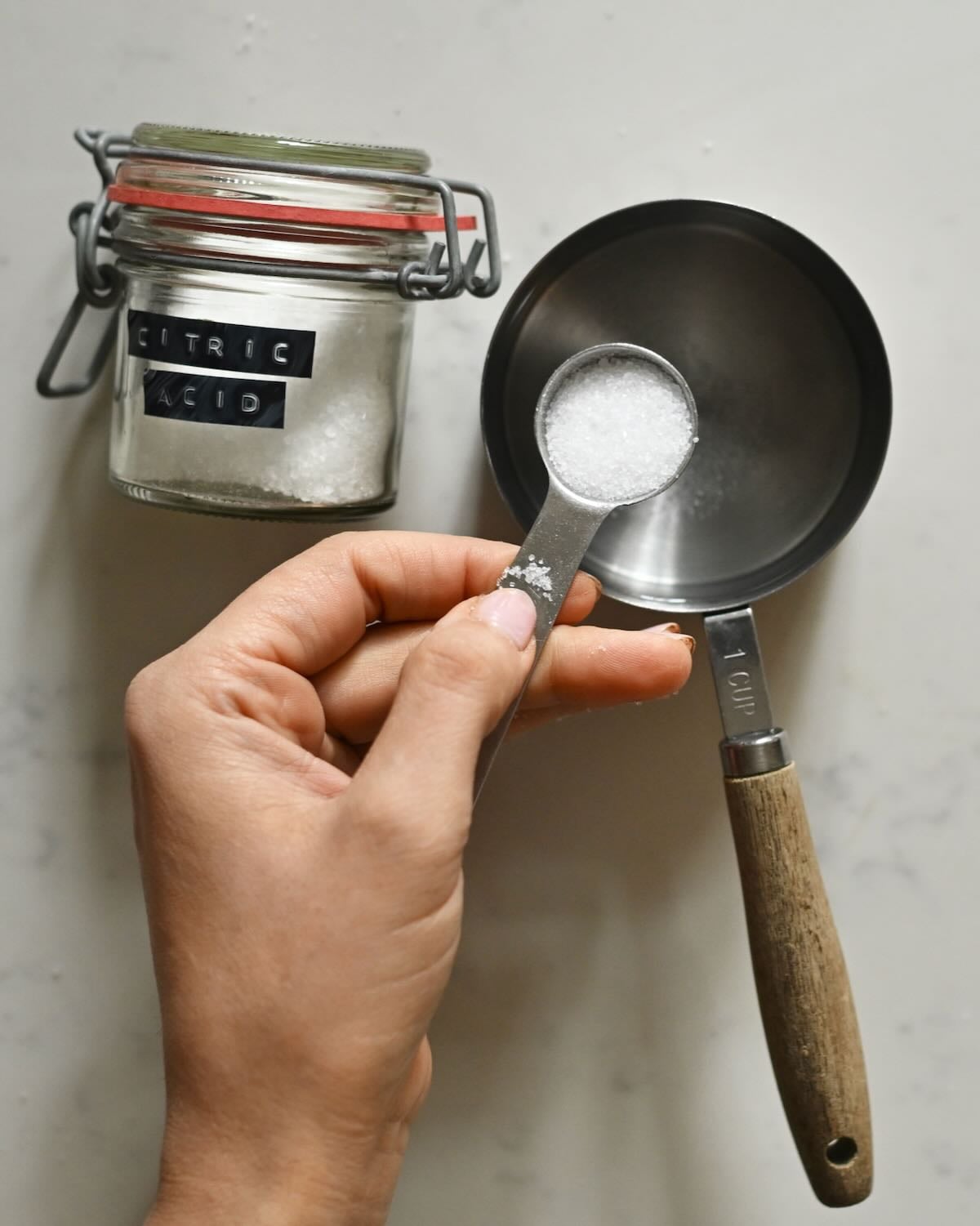 Mixing citric acid in one cup of water.