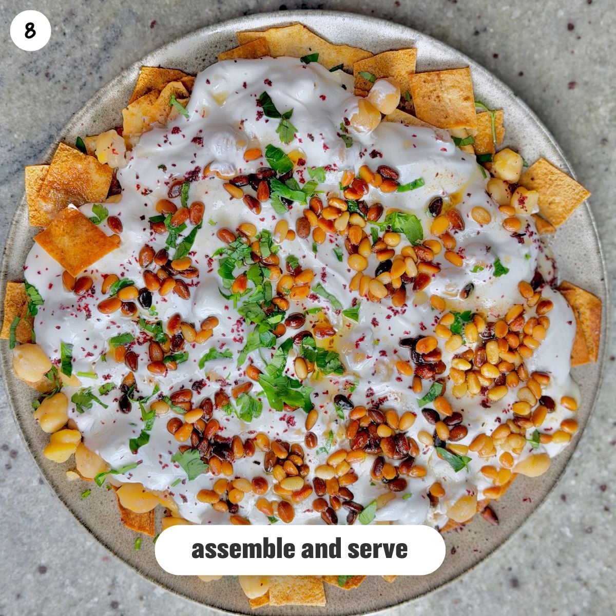 Top view of fattet hummus being served on a white plate.