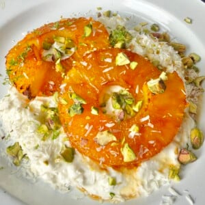 close up of Cottage cheese topped with caramelized pineapple rings, pistachios, coconut flakes, and lime zest.