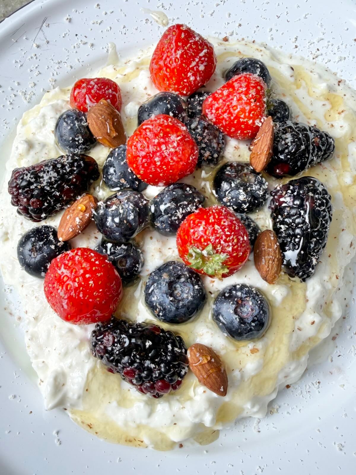 Cottage cheese topped with strawberries, blueberries, blackberries, almonds, and a drizzle of honey.