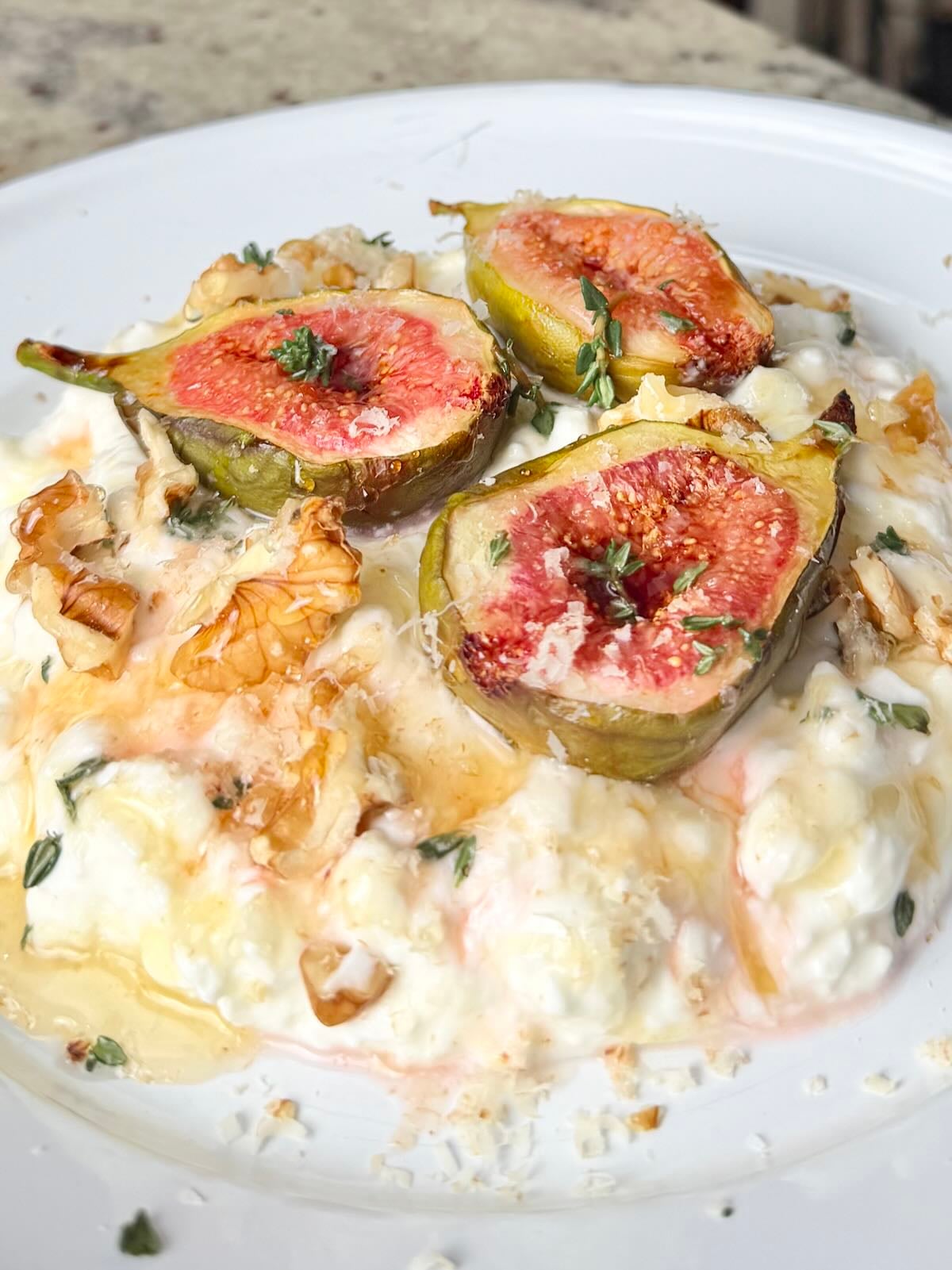Roasted figs over cottage cheese with walnuts, fresh thyme, and honey.