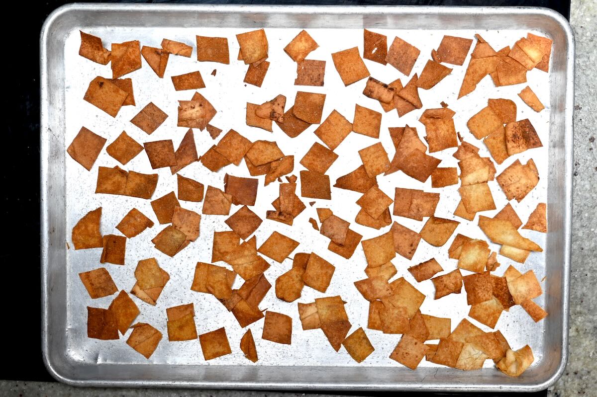 Baked pita chips spread on a sheet pan for fattoush salad.