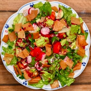 Overhead view of Lebanese fattoush salad with romaine, cucumber, tomato, radish, herbs, and crispy pita chips.