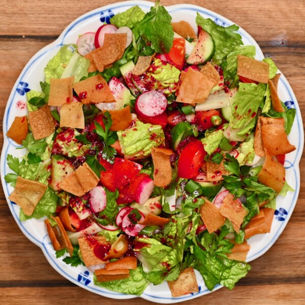 Overhead view of Lebanese fattoush salad with romaine, cucumber, tomato, radish, herbs, and crispy pita chips.