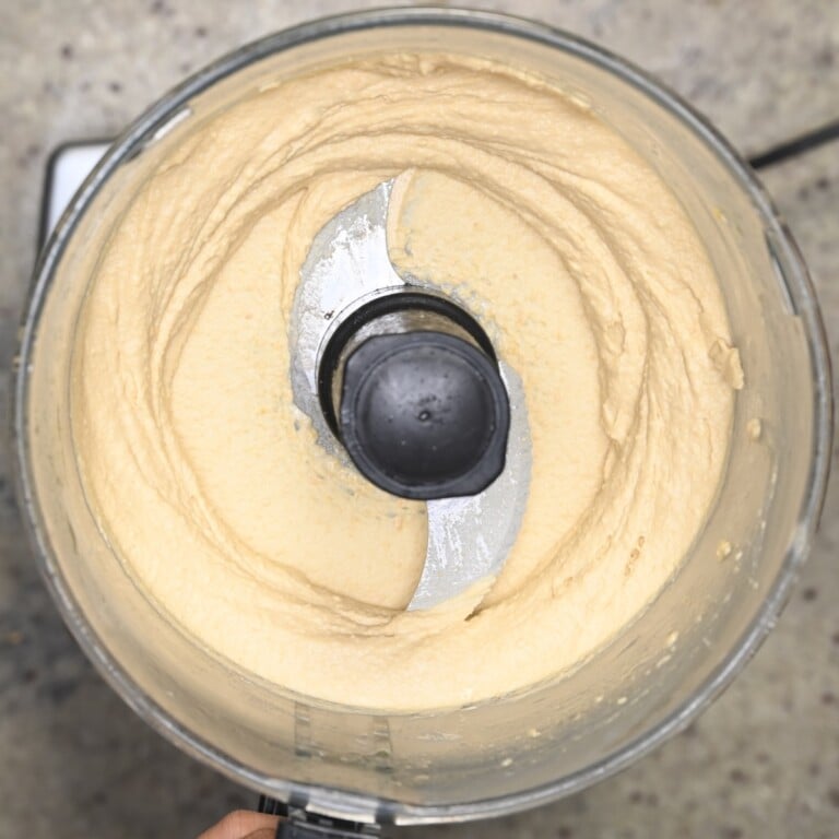 Thick hummus in a food processor after blending.