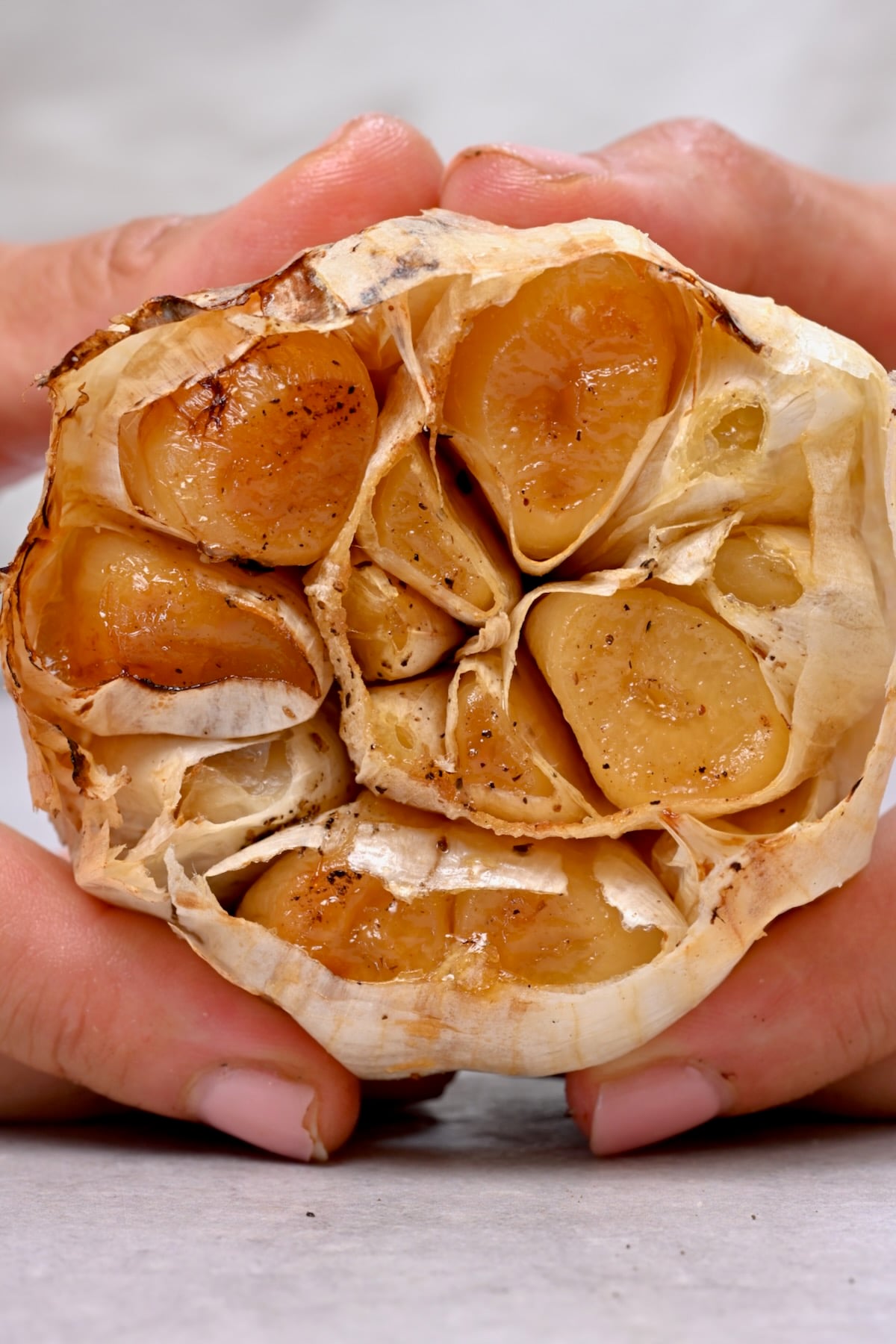 Close-up of a whole roasted garlic head with golden, caramelized cloves.