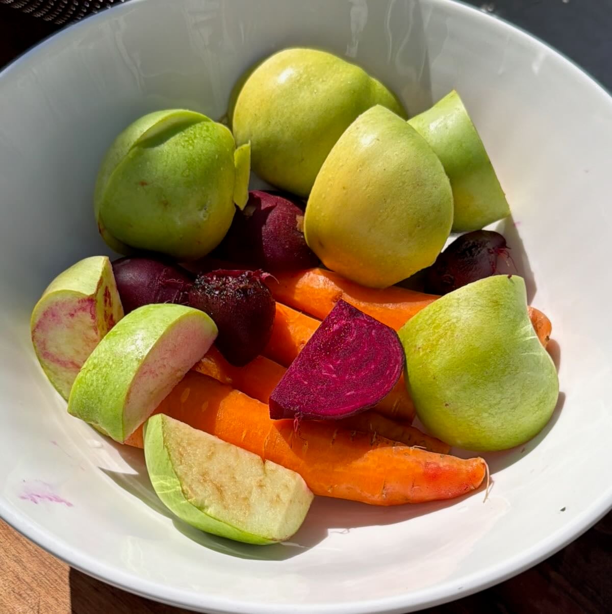Roughly chopped apples, beets, and carrots in a bowl.