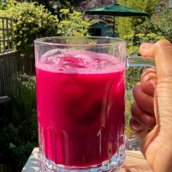 A glass of freshly made ABC juice with a bright ruby color.