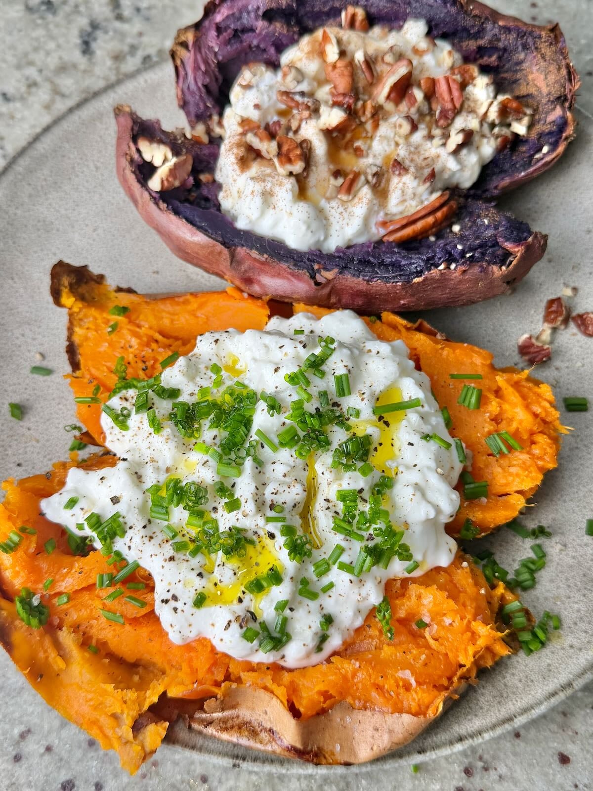 Two sweet potatoes cooked in an air fryer, cut in half, and topped with various toppings.