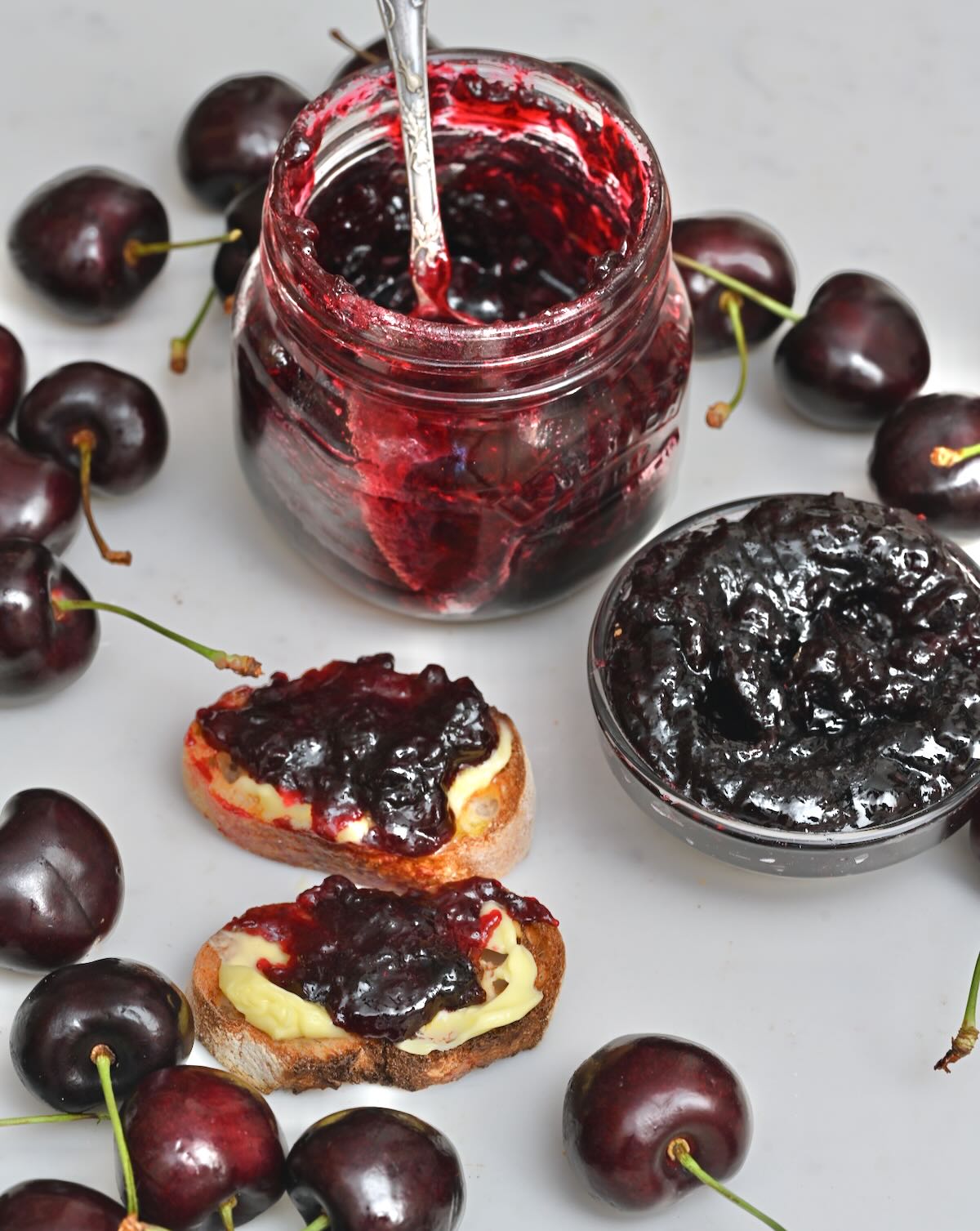 Homemade cherry jam spread over two small slices of bread.