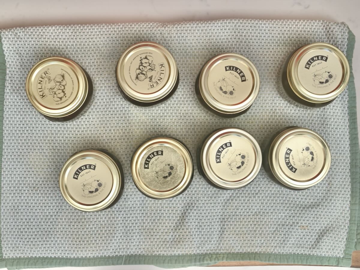 Jars with cherry jam resting after canning.