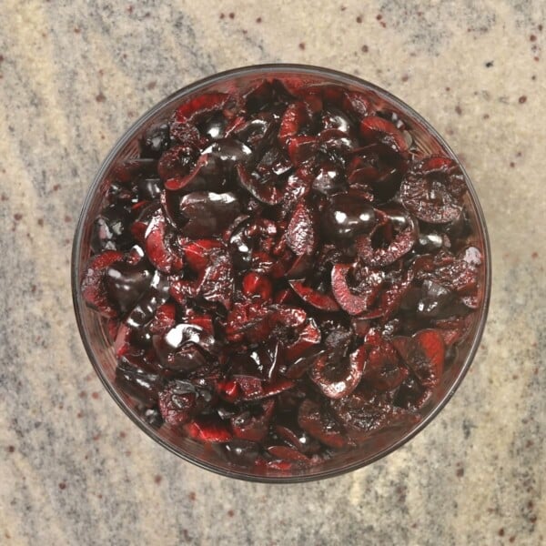 Pitted and halved cherries in a bowl.