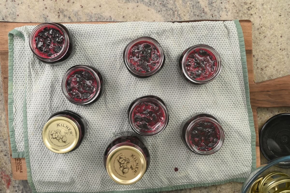 Placing the lids on small jam jars.
