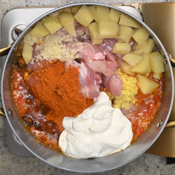 Adding the chicken, yogurt, potatoes and biryani spices.