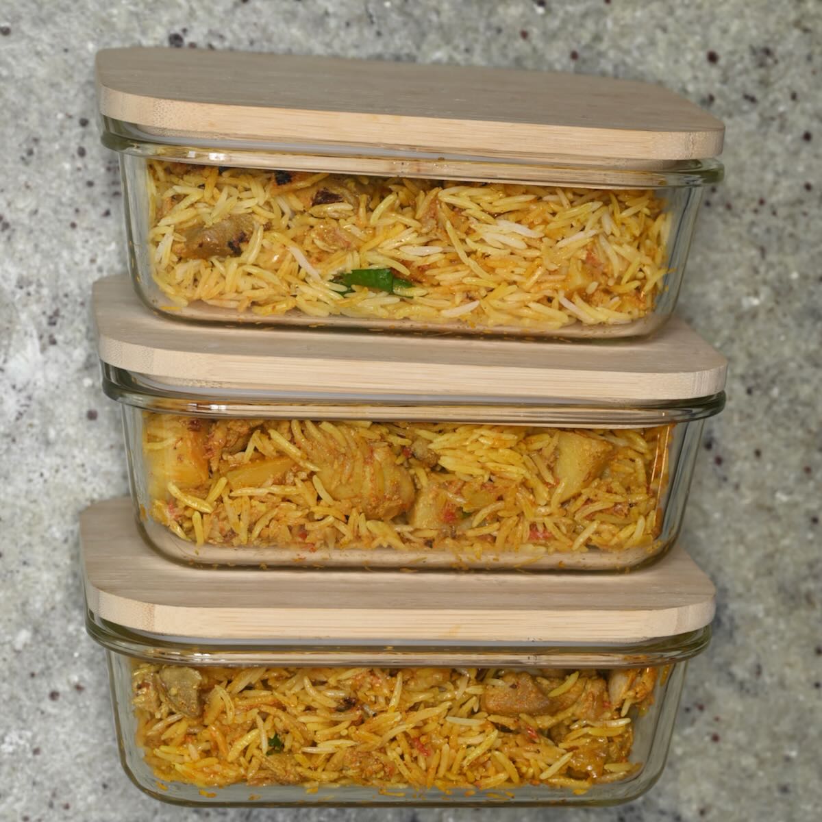 Chicken biryani placed in containers for meal prep.