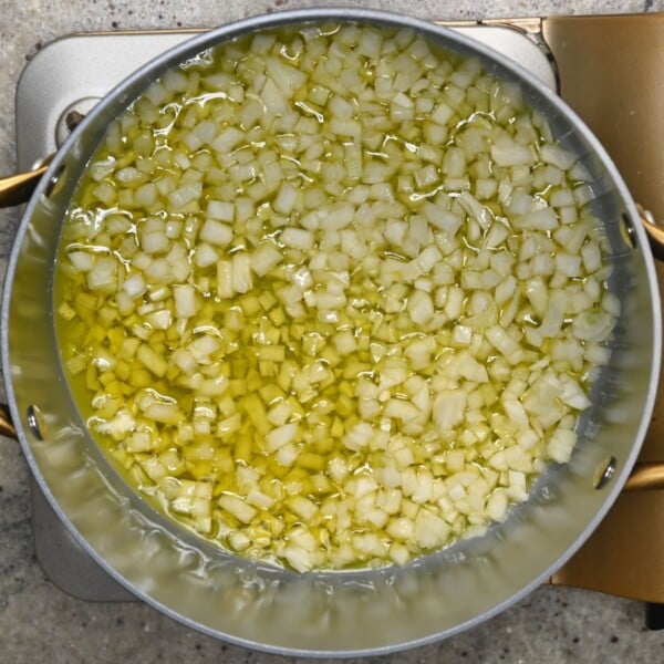 Cooking onions with oil in a large pot.