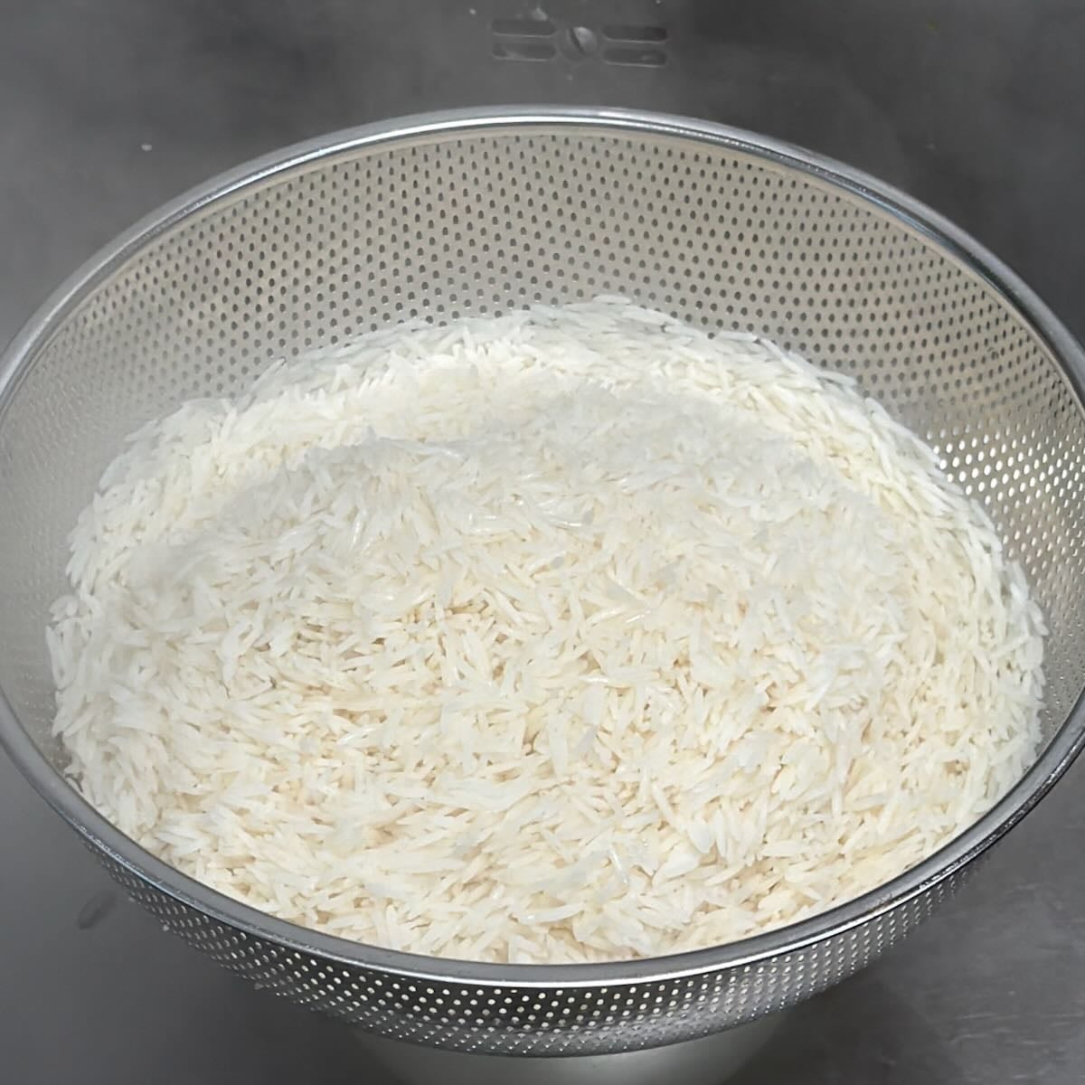 Draining cooked rice in a colander.