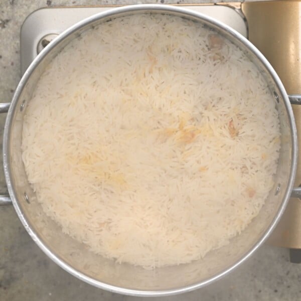 Topping everything with a layer of rice.