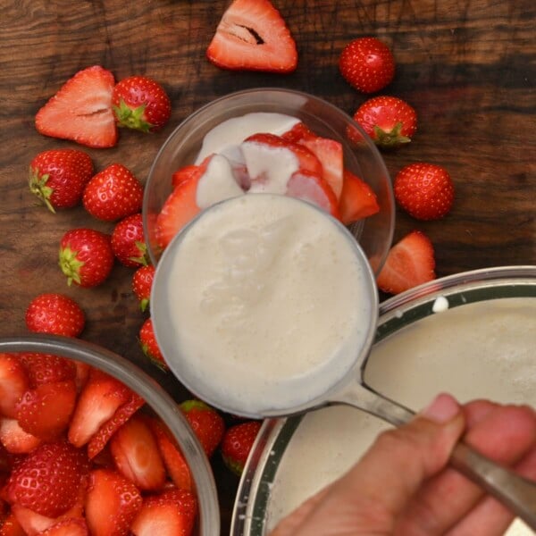 Topping the strawberries with crema.