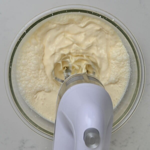Using a mixer to whisk the dairy ingredients.