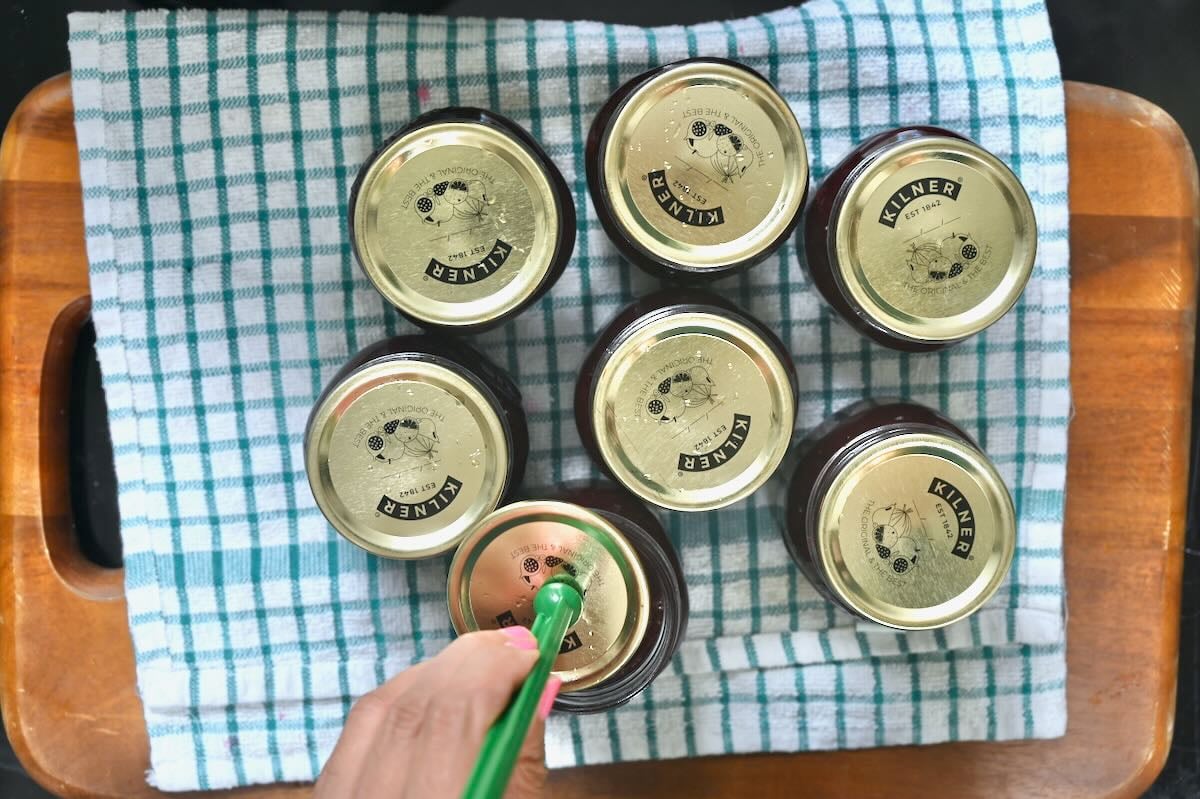 Closing the lids of jars filled with jam.