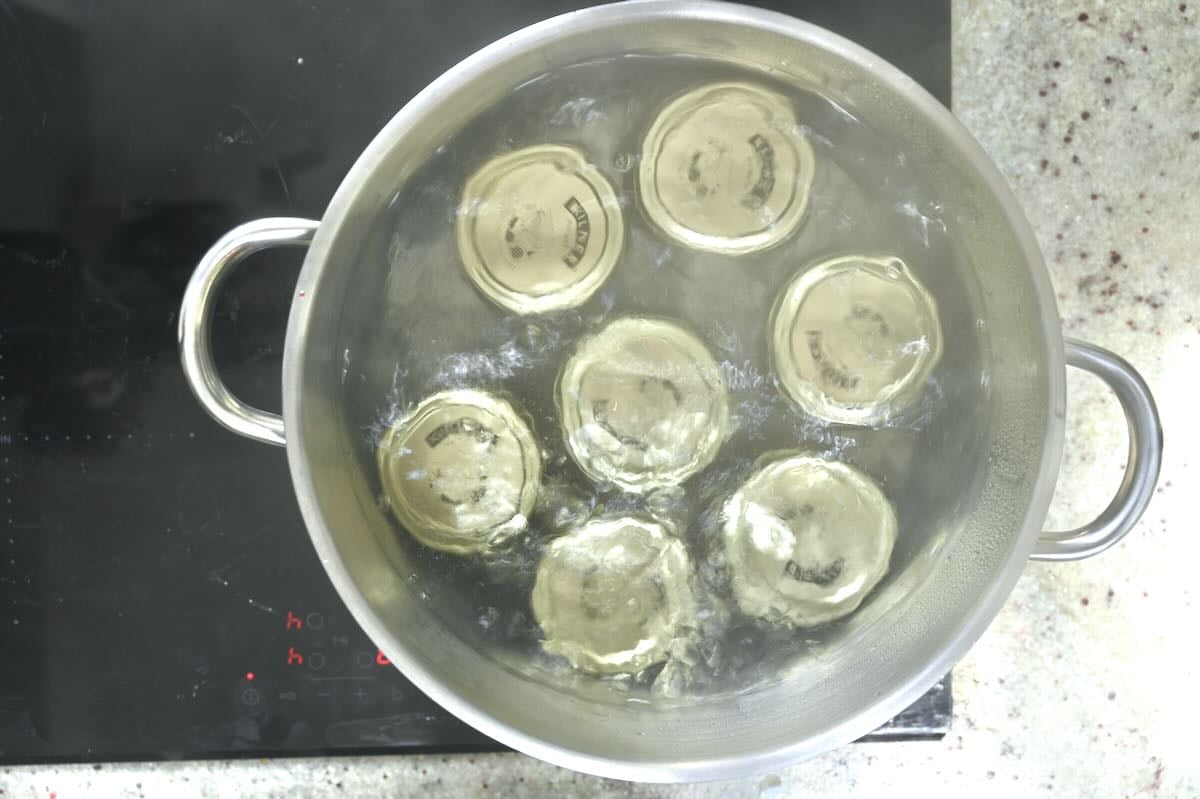 Water bath canning jars with plum jam.